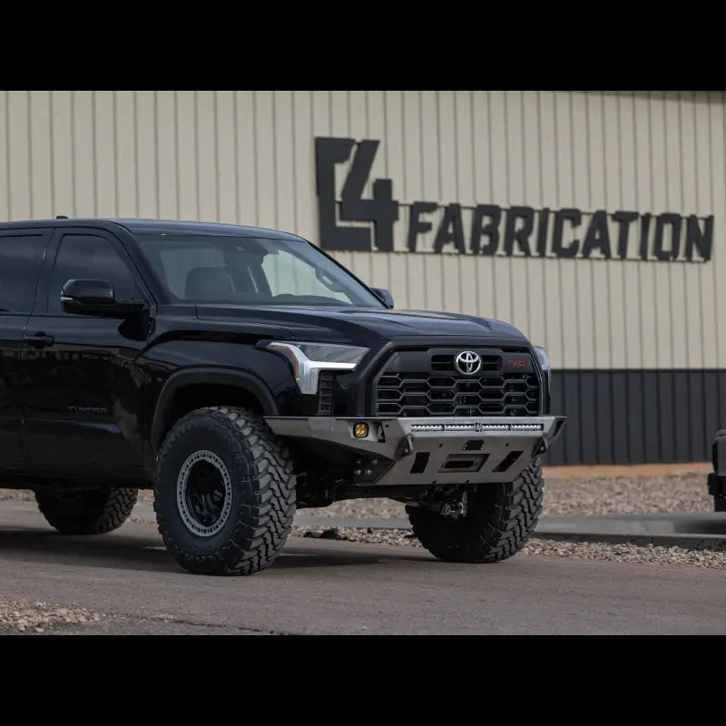 Tundra Overland Front Bumper for 3rd Gen 2022+ in bare steel finish, mounted on a black Tundra, displayed outside L4 Fabrication.