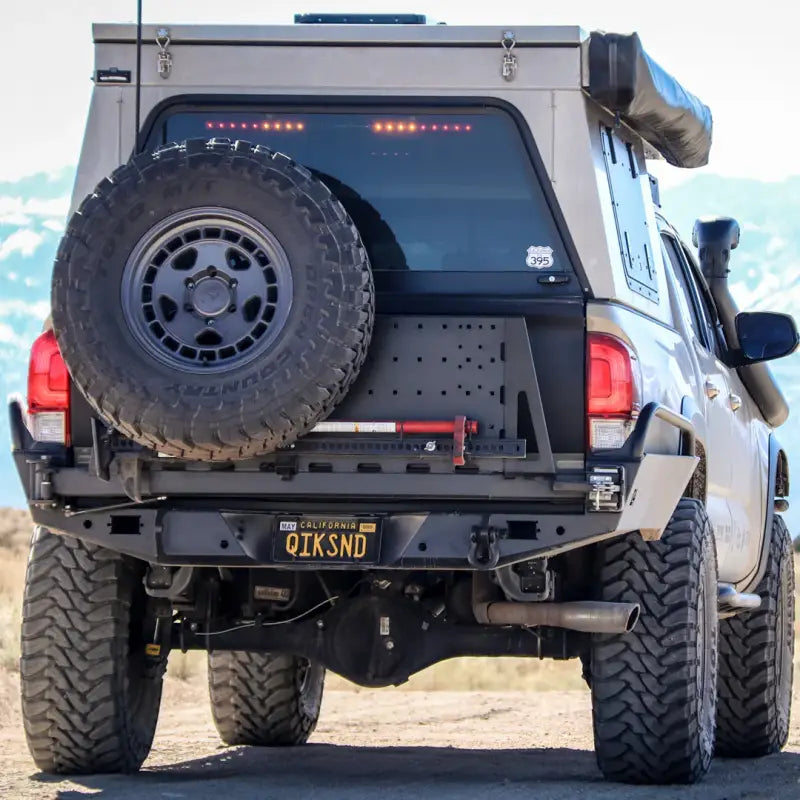 Tacoma Overland high clearance rear bumper installed on a 3rd Gen 2016+ Tacoma with spare tire mount and off-road accessories.
