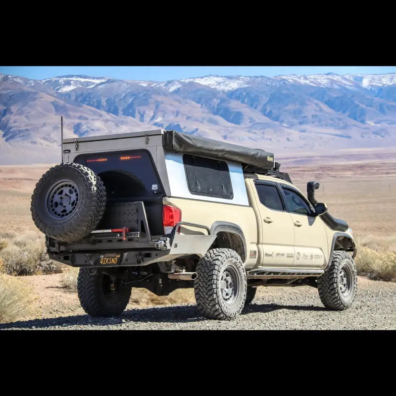 Tacoma Overland high clearance rear bumper on a 3rd Gen 2016+ Tacoma with off-road accessories in a desert landscape.