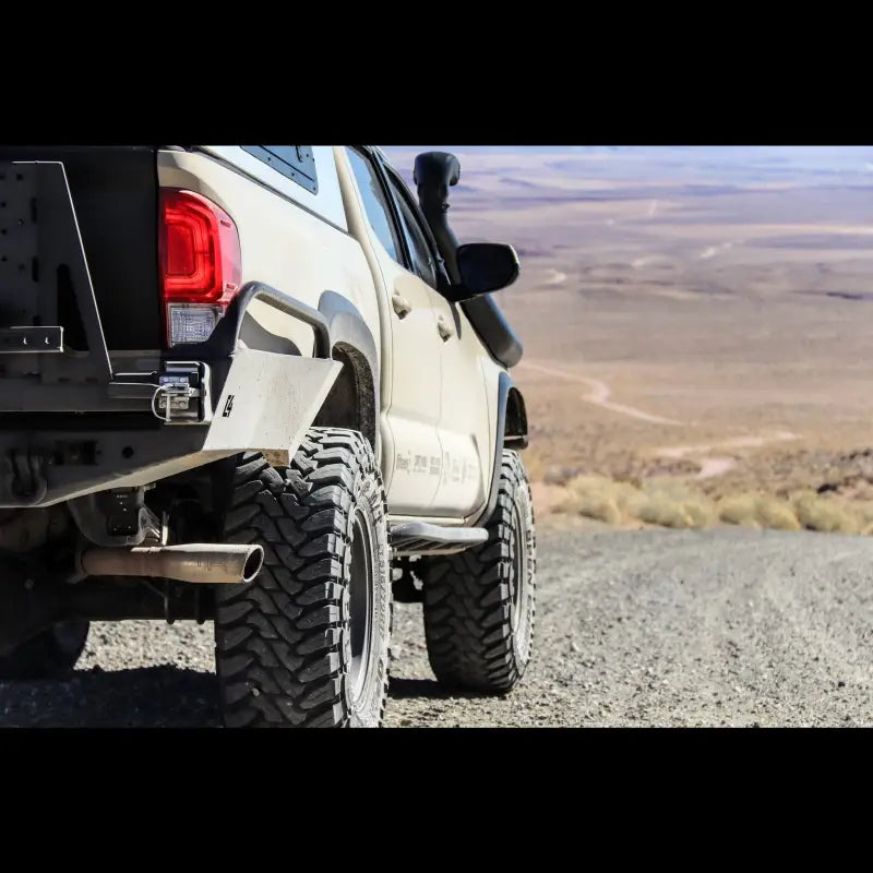 Close-up of Tacoma Overland high clearance rear bumper on a 3rd Gen 2016+ Tacoma, showcasing off-road tires and rugged design.