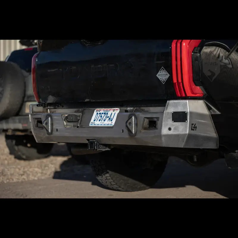 Raw steel Tundra Overland Rear Bumper for 2022+ models, designed with reverse lights and OE hitch compatibility, installed on black truck.