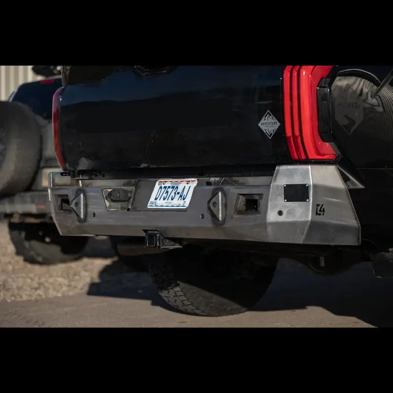 Raw steel Tundra Overland Rear Bumper for 2022+ models, designed with reverse lights and OE hitch compatibility, installed on black truck.