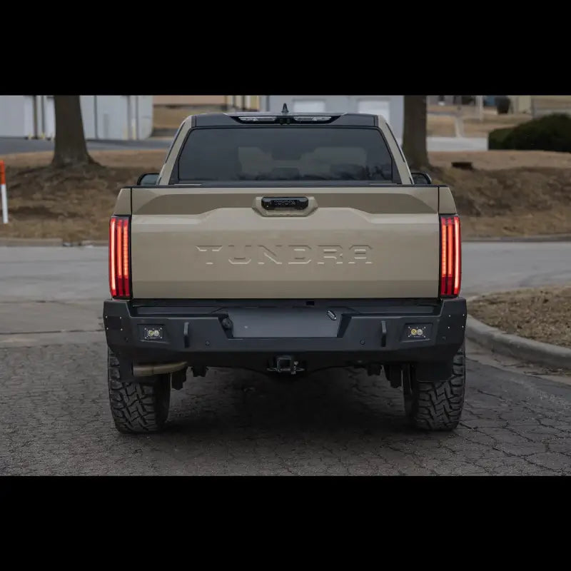 Rear view of Tundra Overland Rear Bumper for 2022+ models in black steel, showcasing reverse lights and robust design on beige truck.