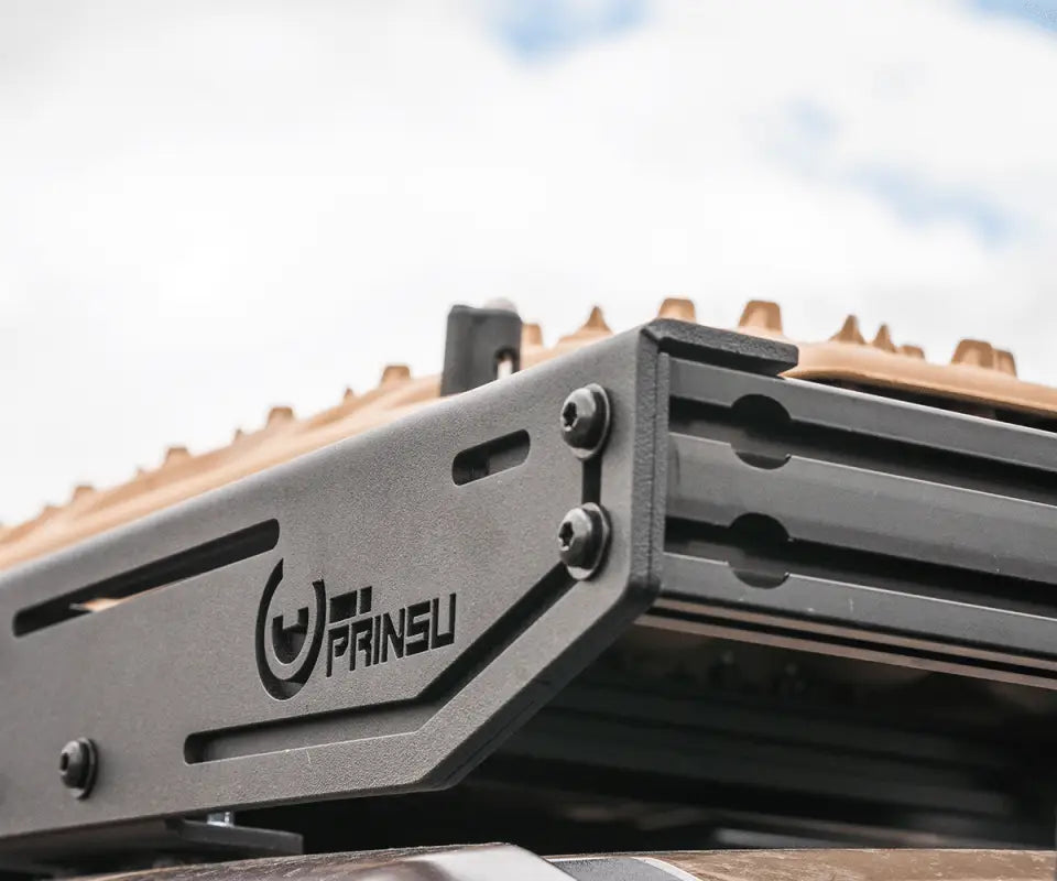 Close-up of Prinsu Pro Roof Rack corner bracket with logo, emphasizing its stainless steel construction and durability.