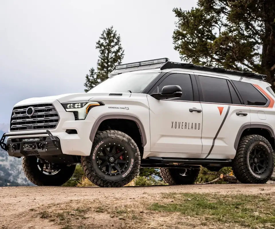 Toyota Sequoia 2023 with Prinsu roof rack and off-road enhancements, parked in a scenic outdoor location with trees in the background.