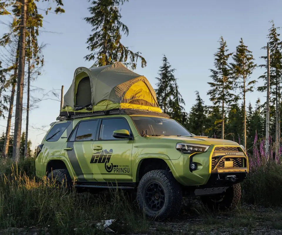 Toyota 4Runner with Prinsu Roof Rack and rooftop tent setup, parked in a forest, highlighting off-road and camping capabilities.