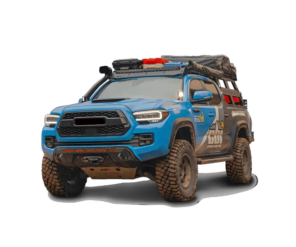 Blue Toyota Tacoma equipped with Prinsu Cab Rack and desert air intake, featuring off-road modifications and cargo setup.