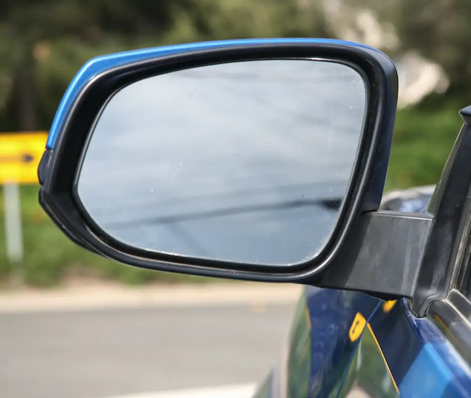 Driver-side mirror of a Tacoma with Puddle Pods LED light installed, blending seamlessly with OEM design.