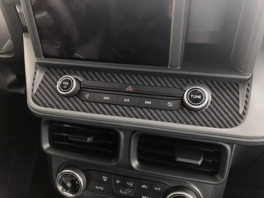 Car dashboard with carbon fiber trim showing radio control accent overlay for Ford Maverick