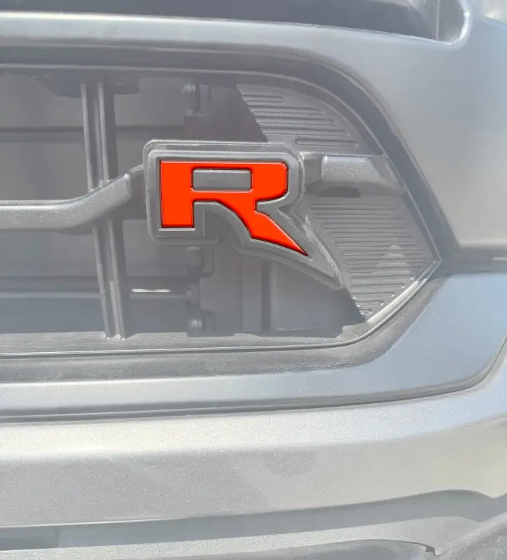 Orange R emblem insert on gray grill for Ford F-150 Raptor 2022-2024