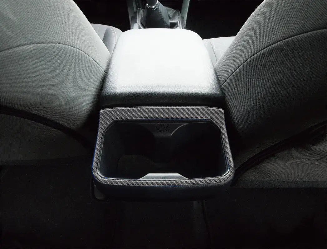 Close-up of rear cup holder accent overlay in carbon fiber finish installed on a Toyota Tacoma, showcasing a sleek and modern interior upgrade.