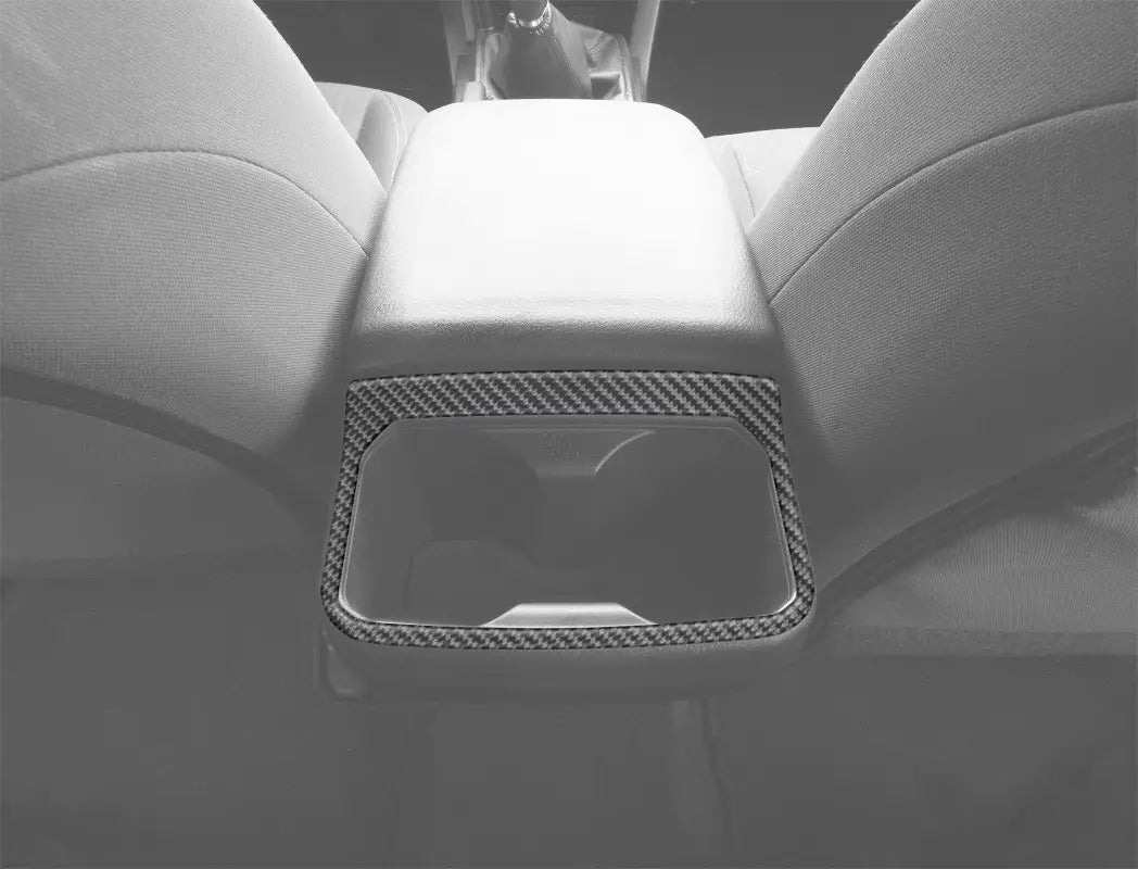 Rear cup holder accent overlay in carbon fiber finish installed on a 2016-2023 Toyota Tacoma interior, enhancing the center console design.