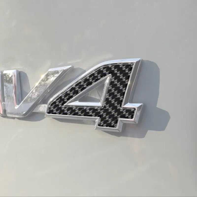 Close-up of carbon fiber-style rear emblem '4' letter insert on a Toyota Rav4, compatible with 2019-2024 models.