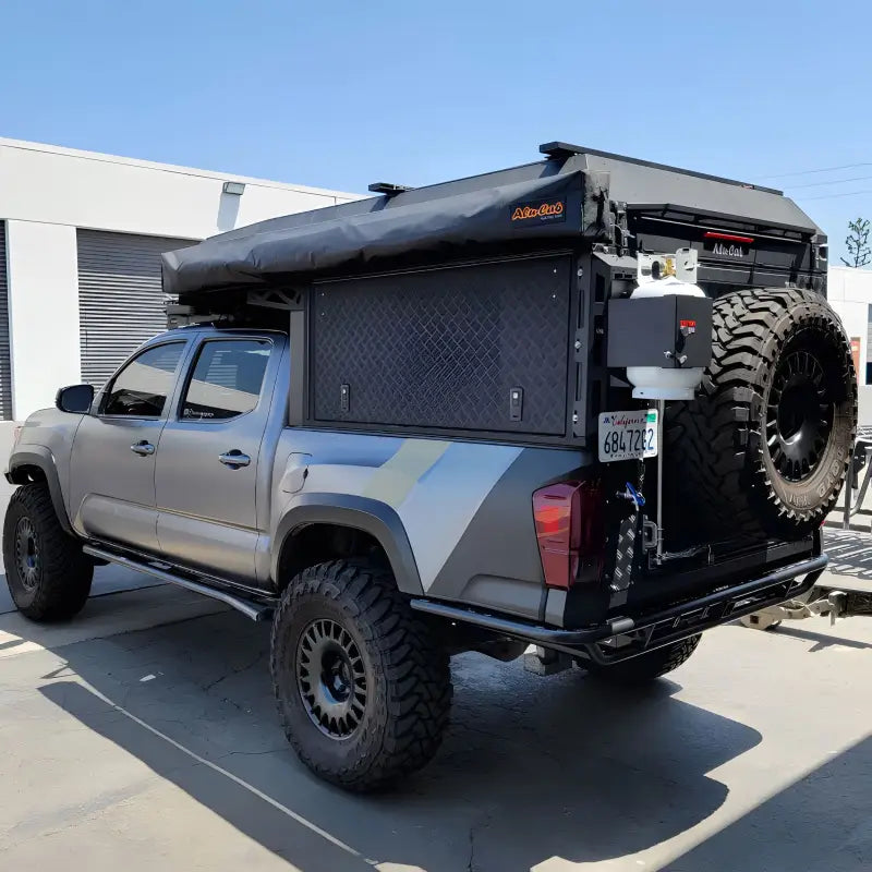 2016+ Tacoma Tube Bumper - High Clearance with durable design, mounted on a silver Toyota Tacoma with off-road accessories and spare tire.