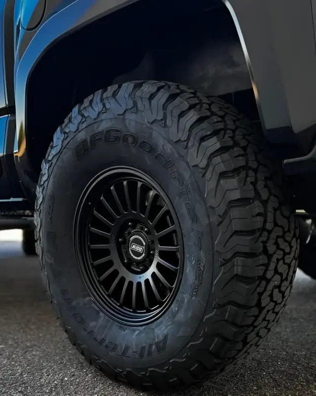 Black off-road tire and rim from RG6-S MonoForged Series with lug nuts and center caps