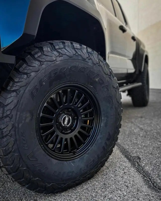 Black off-road tire and rim from RG6-S MonoForged Wheel Series with lug nuts and center caps