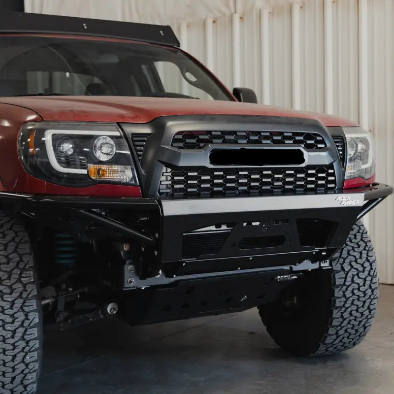 Front angled view of a 2005-2015 Toyota Tacoma with the Rock Runner modular bumper and integrated control features.