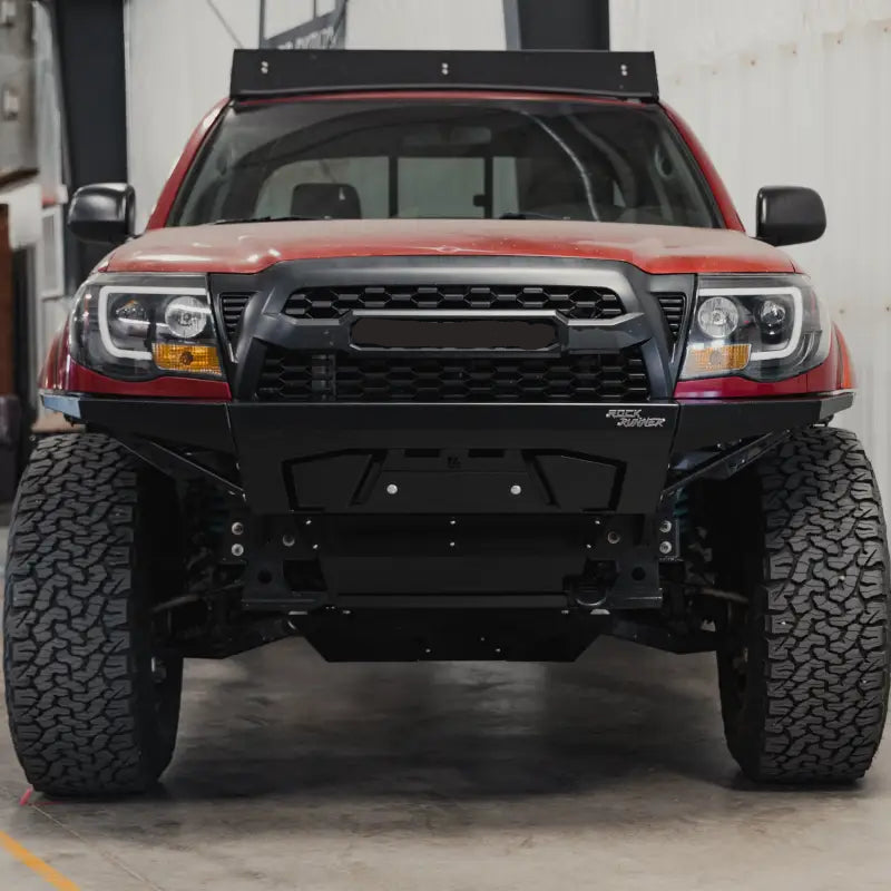 Front view of a 2005-2015 Toyota Tacoma with a Rock Runner modular front bumper featuring bolt-on wings and winch compatibility.