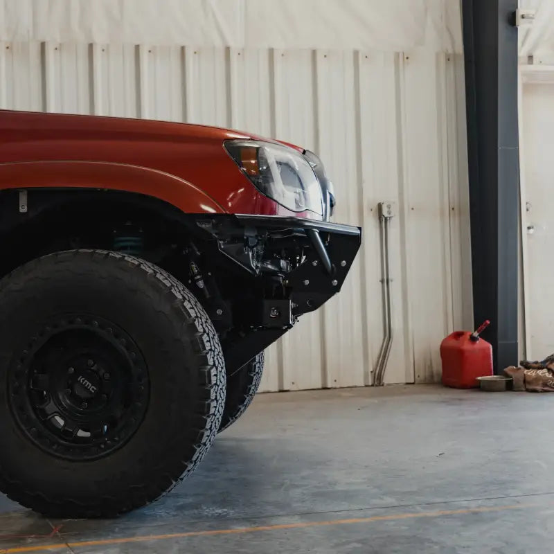 Side view of a red Tacoma featuring a skid plate with cross member delete. Designed for off-road durability and improved ground clearance.