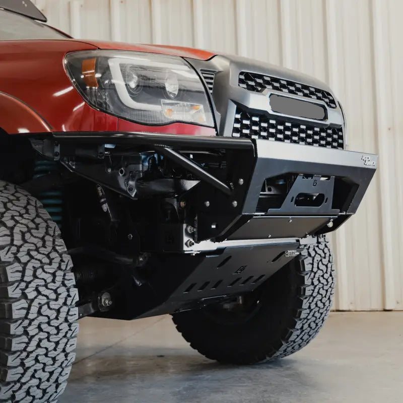 2005-2015 Tacoma skid plate with cross member delete installed on a red truck. High-clearance design protects the engine and allows easy oil changes.