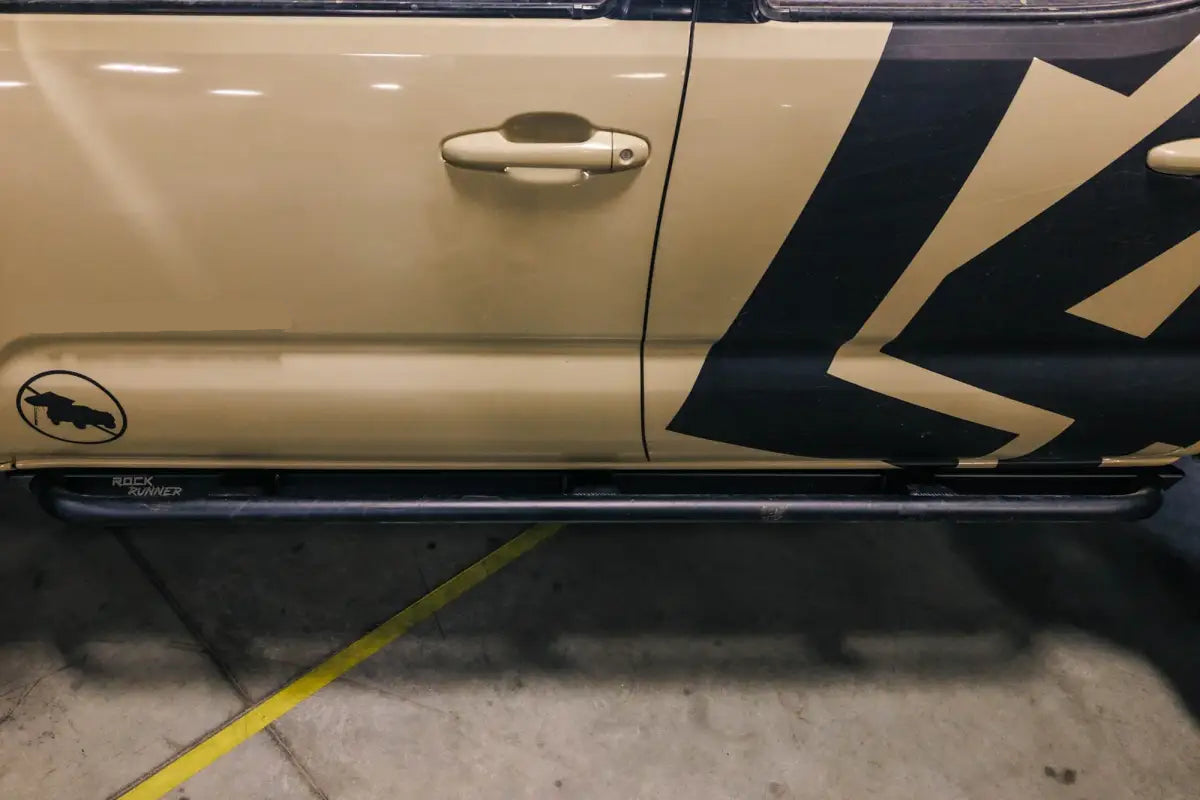Full side profile of Tacoma with Rock Runner Sliders, showing bolt-on installation and compatibility with 2016+ models.