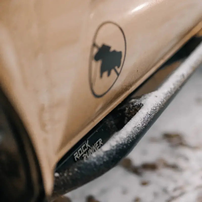 Close-up of Tacoma Rock Runner Sliders with snow, showcasing durable bolt-on design for 2016+ Tacoma models.