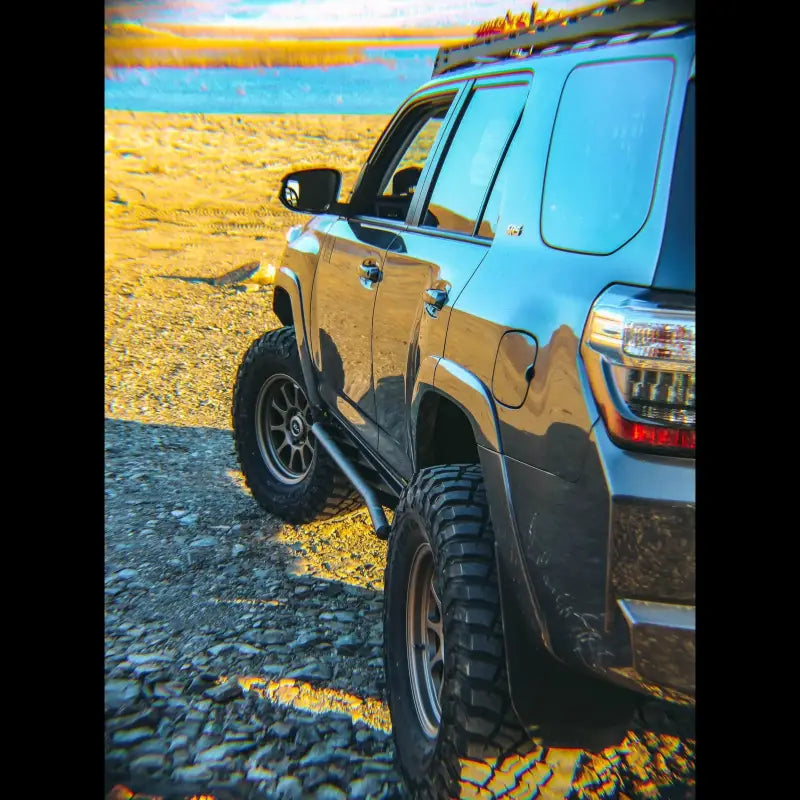 5th Gen 4Runner equipped with rock sliders driving on rocky terrain, highlighting off-road protection and durable construction.
