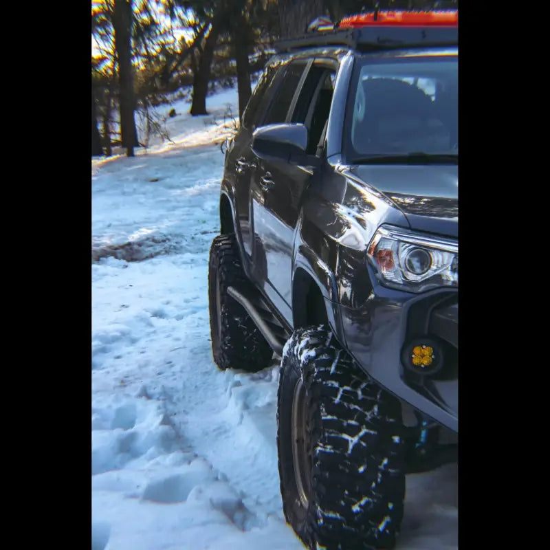 5th Gen 4Runner with rock sliders navigating snowy terrain, emphasizing off-road durability and vehicle side protection.