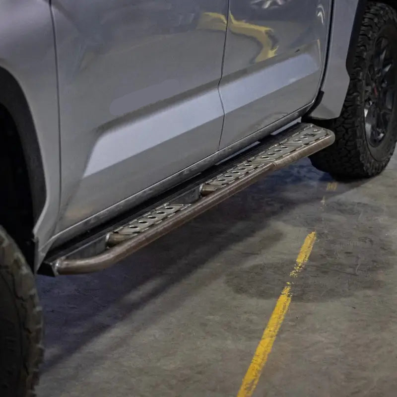 Close-up of Tundra rock sliders installed on a 3rd Gen 2022+ truck, showcasing strong mounting and sleek design.