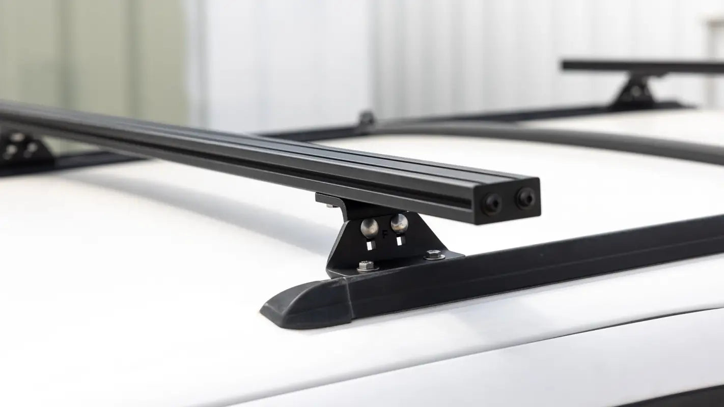 Angled view of Roof Track Load Bars mounted on a vehicle, highlighting the universal design and compatibility with roof tracks.