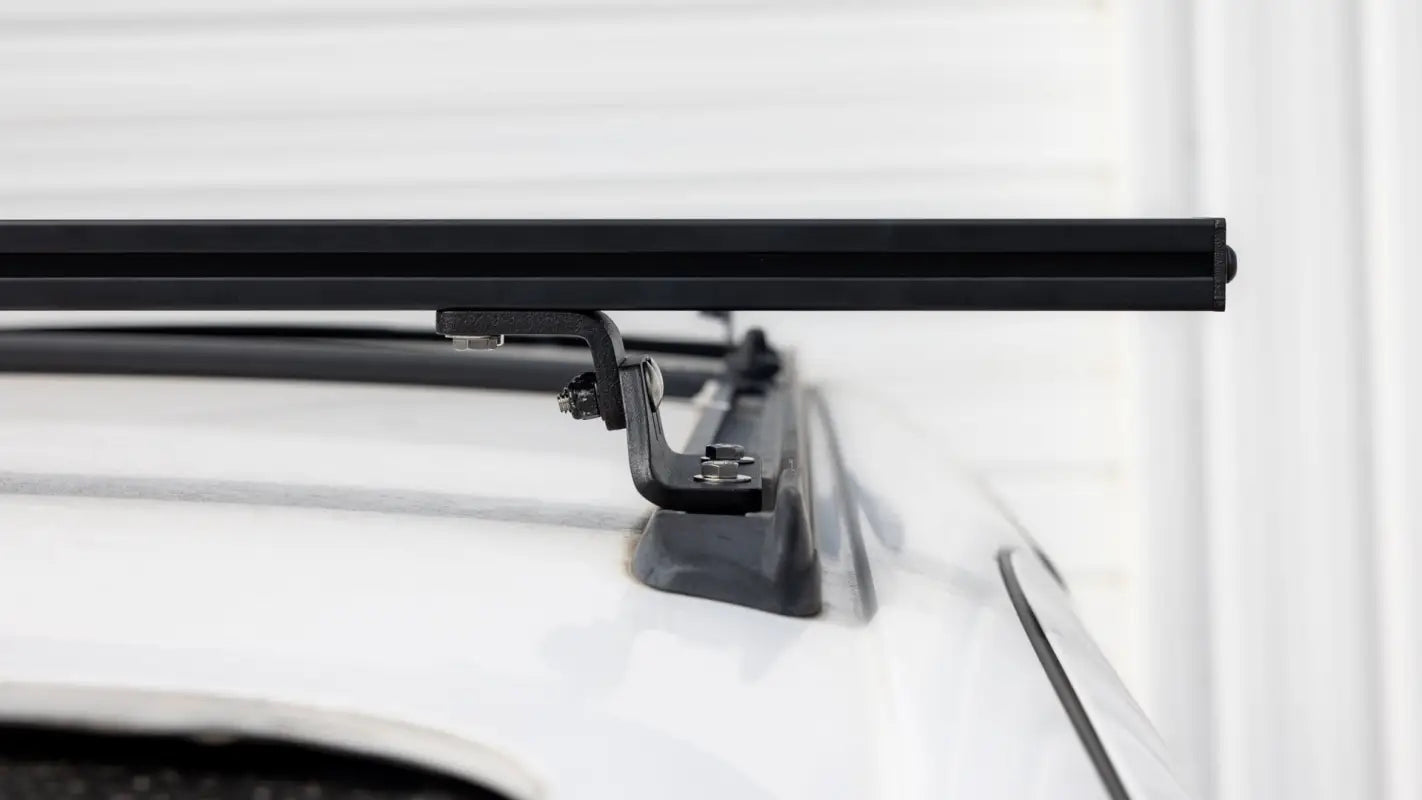 Side view of Roof Track Load Bars installed on a vehicle roof, showcasing the low-profile and practical mounting system.