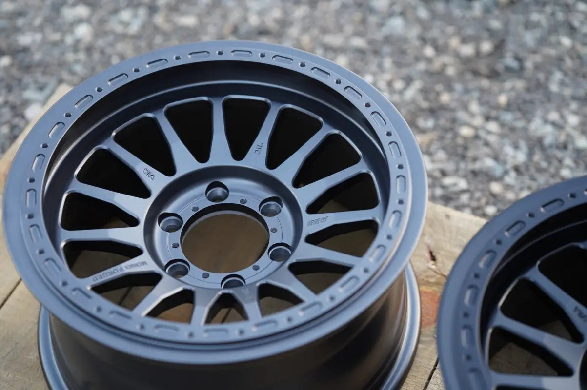Gray alloy RS7-H Hybrid Monoforged Wheel with lug nuts and center caps for premium vehicles