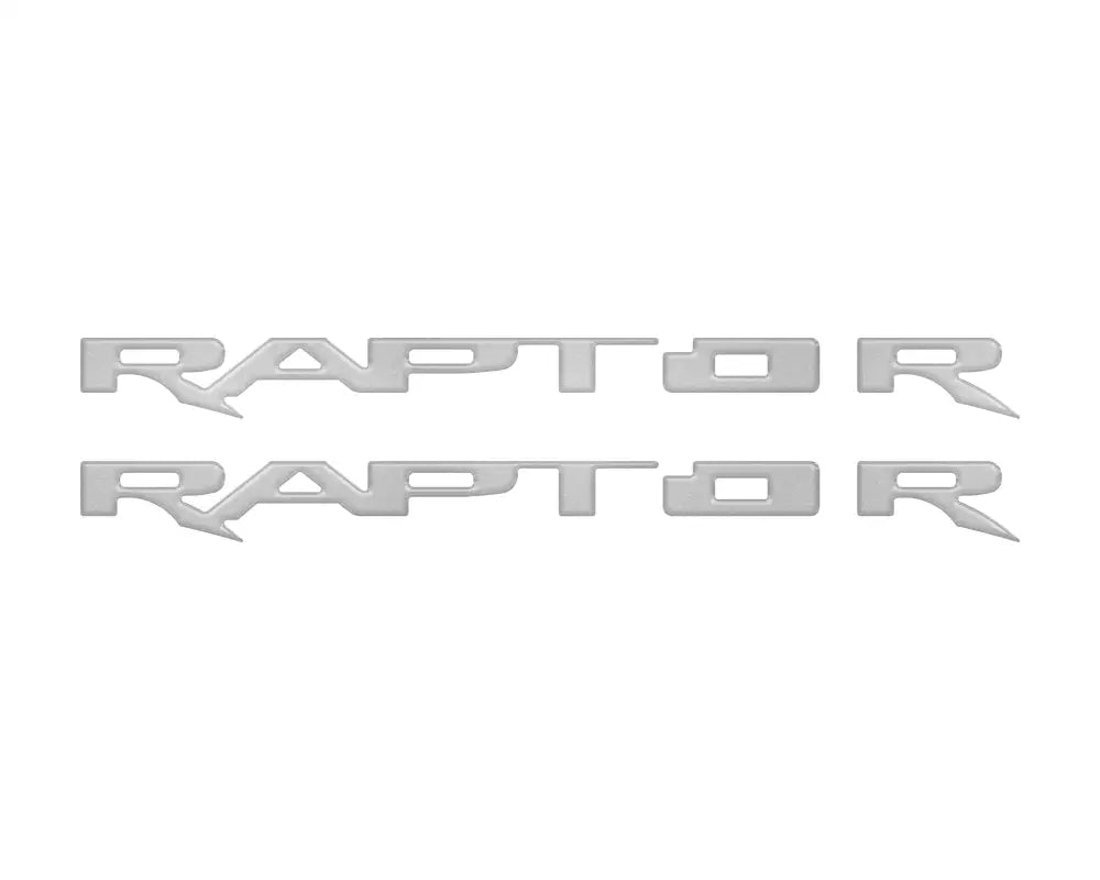 Two silver RAPTOR emblem overlays for running board emblems on 2017-2025 Ford Raptor