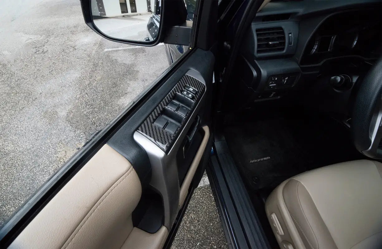 Close-up view of carbon fiber side door control accent trim fitted on a Toyota 4Runner, showcasing a modern and durable upgrade.