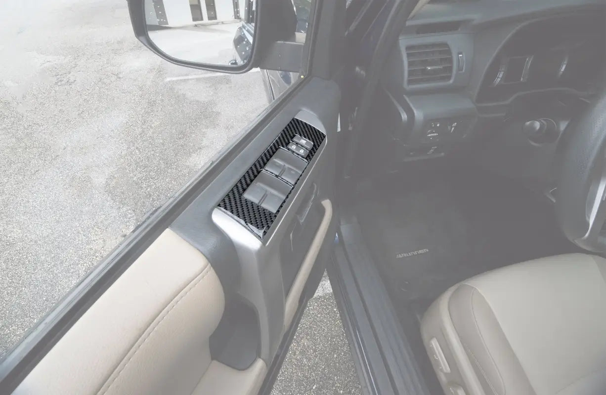 Side door control accent trim installed on a 2014-2024 Toyota 4Runner, featuring a sleek carbon fiber design for enhanced interior style.