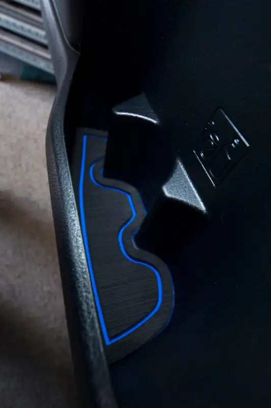 Black and blue side door pocket cup holder insert fitted in a 2016-2023 Toyota Tacoma, enhancing interior aesthetics and functionality.