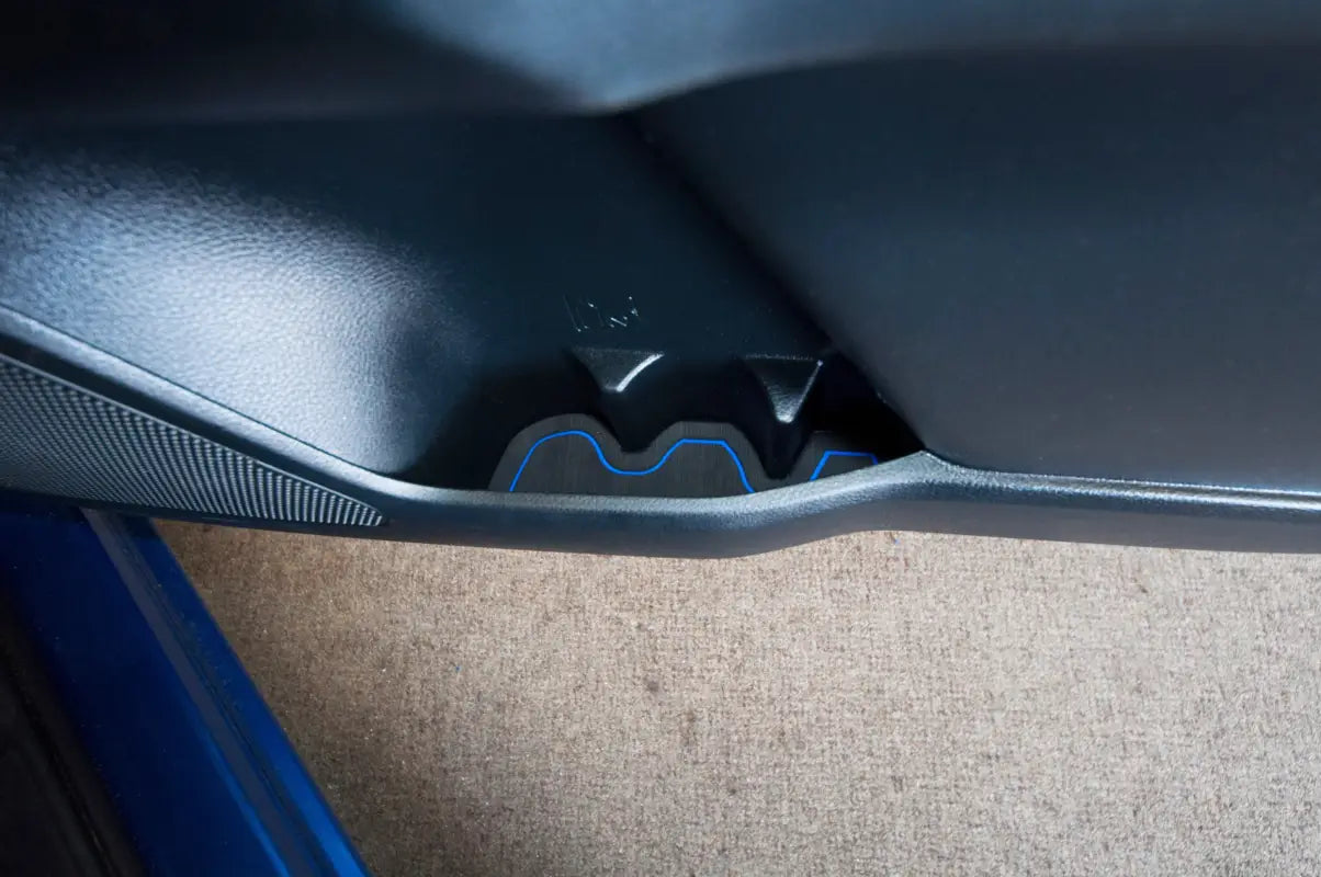 Wide view of a side door pocket cup holder insert with blue accents installed in a Toyota Tacoma, designed for 2016-2023 models.