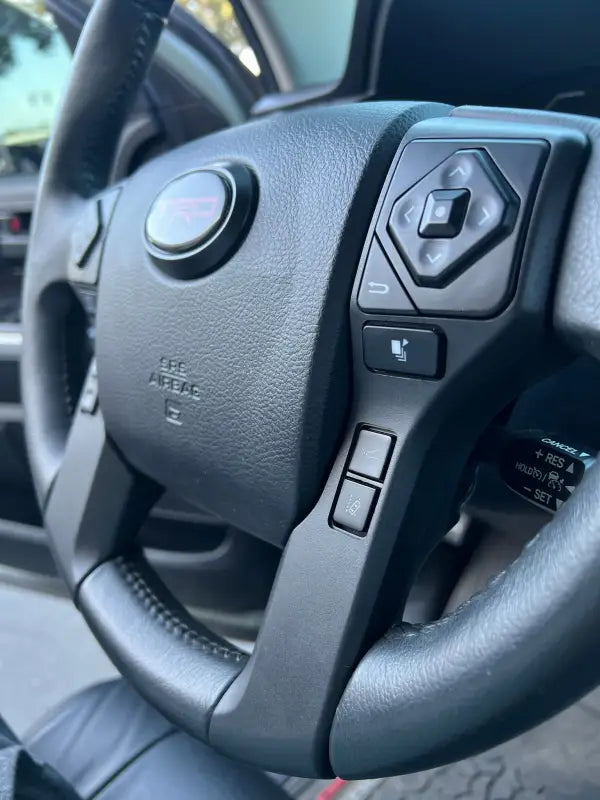 Installed steering wheel blackout surround on a Toyota Tacoma, enhancing the interior with a modern, sleek look.