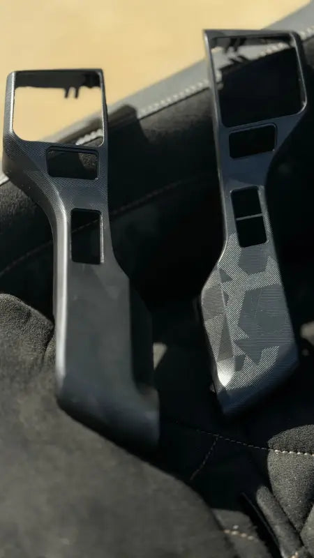 Textured steering wheel blackout surround inserts displayed on a car seat, compatible with 2016-2023 Toyota Tacoma.