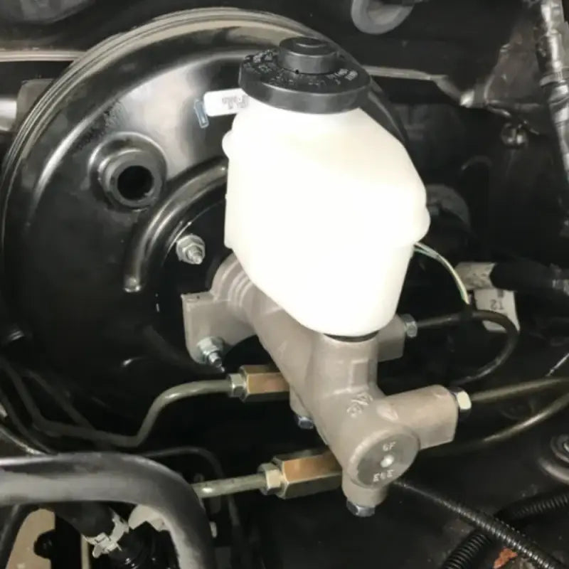 Close-up of Toyota Tacoma master cylinder installed in engine bay, showcasing compatibility with rear disc brake conversion.