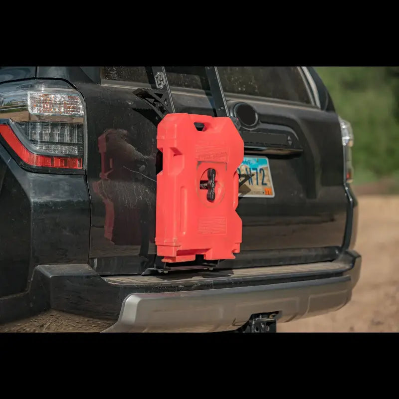 Close-up of Summit Ladder Rotopax Bracket on a 5th Gen 4Runner with a red Rotopax container securely mounted. Durable and functional design.
