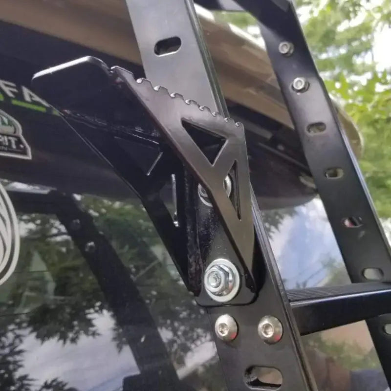 Close-up of the 4Runner Summit Hatch Ladder Side Step in black powder coat finish, securely bolted onto a ladder for easy access.