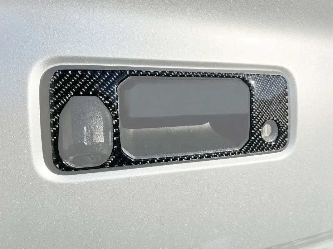 Carbon fiber tailgate handle accent overlay installed on a 2016-2023 Toyota Tacoma, enhancing the vehicle's exterior with a sleek design.