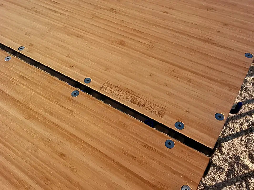 Close-up of bamboo surface with TemboTusk branding, showcasing durable and high-quality materials for outdoor use.