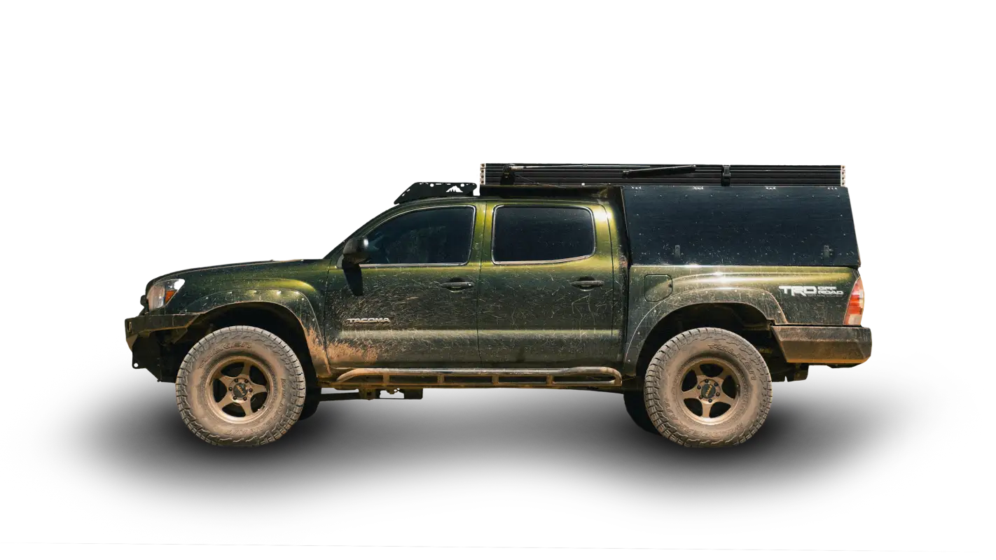 Green Toyota Tacoma with Animas roof rack and camper setup, showcasing durable and versatile storage for off-road adventures.