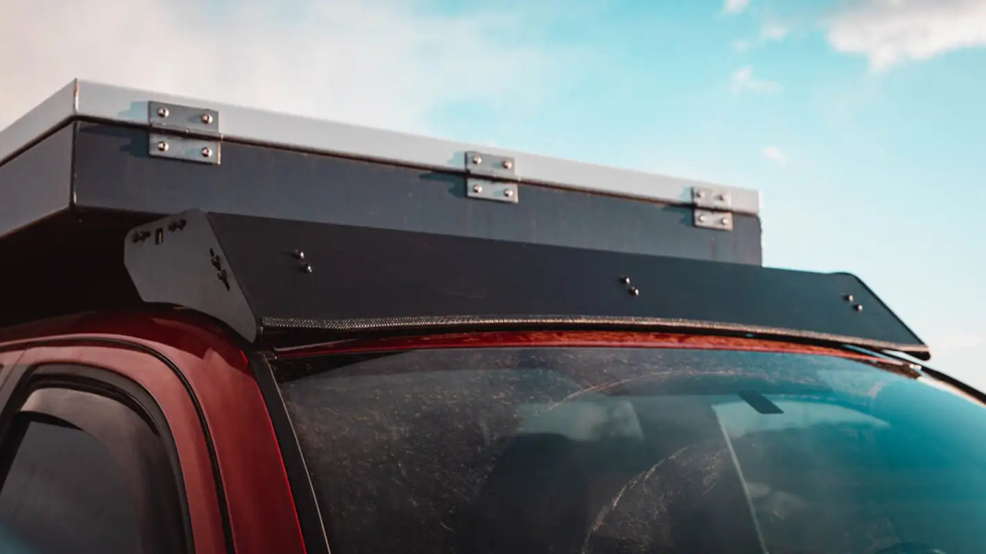 Close-up of Animas roof rack fairing on a red Toyota Tacoma, showcasing its aerodynamic and durable construction.