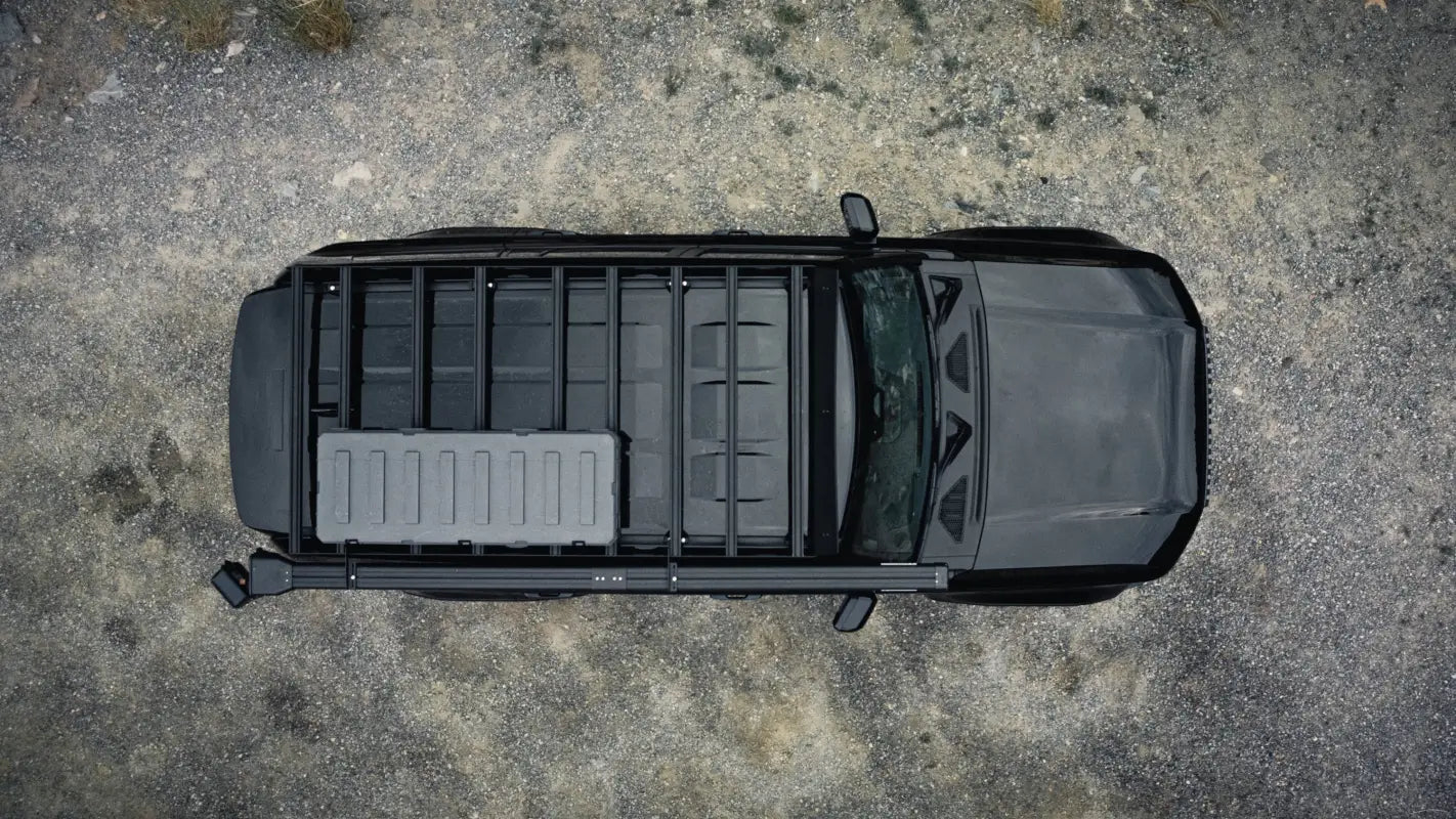 Top-down view of The Atlas roof rack on a black 2024 Toyota Land Cruiser, featuring a mounted storage box and modular rails.