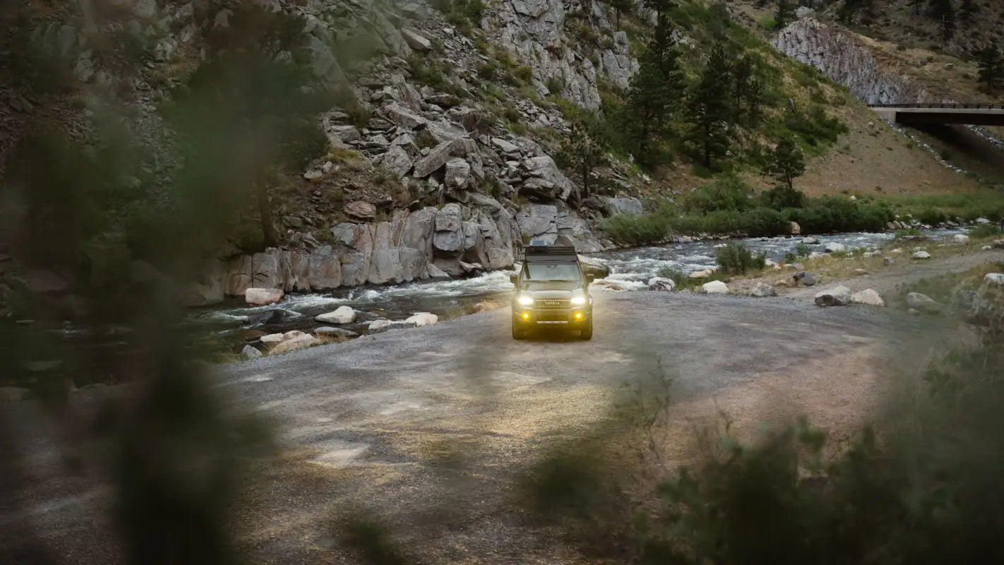 2024 Toyota Land Cruiser with The Atlas roof rack parked near a river, blending rugged utility with outdoor adventure.
