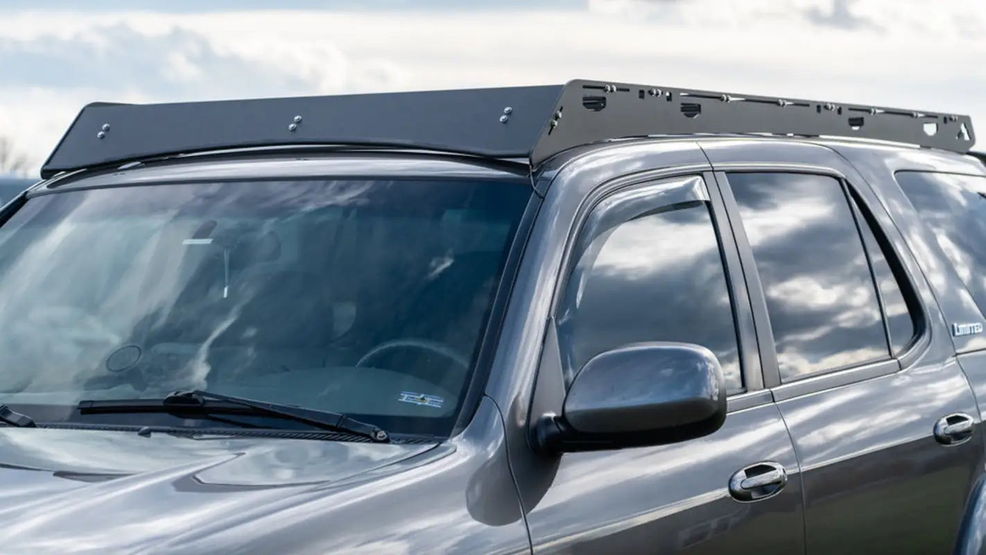 Front-side view of the Belford roof rack on a silver 2001-2007 Toyota Sequoia, emphasizing its aerodynamic design and black finish.
