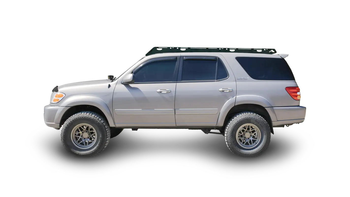 Side view of a silver 2001-2007 Toyota Sequoia equipped with the Belford aluminum roof rack, featuring a sleek black finish and drill-free installation.